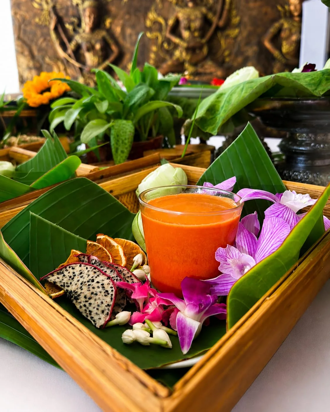 Fresh juice with tropical fruit and orchids on a banana-leaf tray