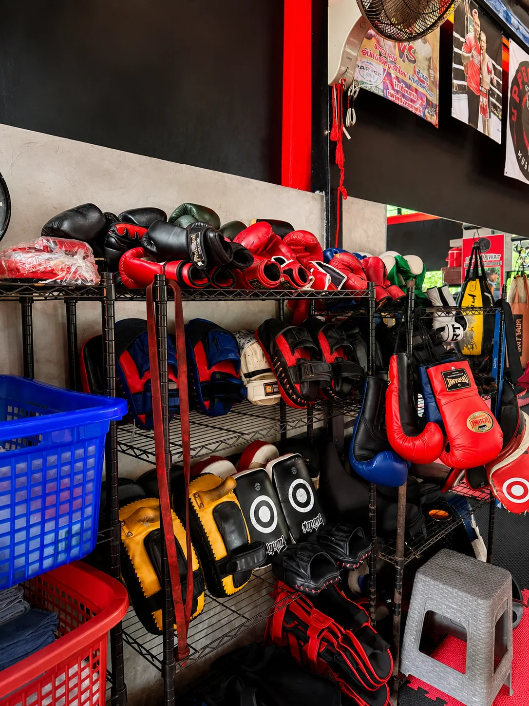 Rack of Muay Thai gloves and equipment at the Phuket Cleanse gym