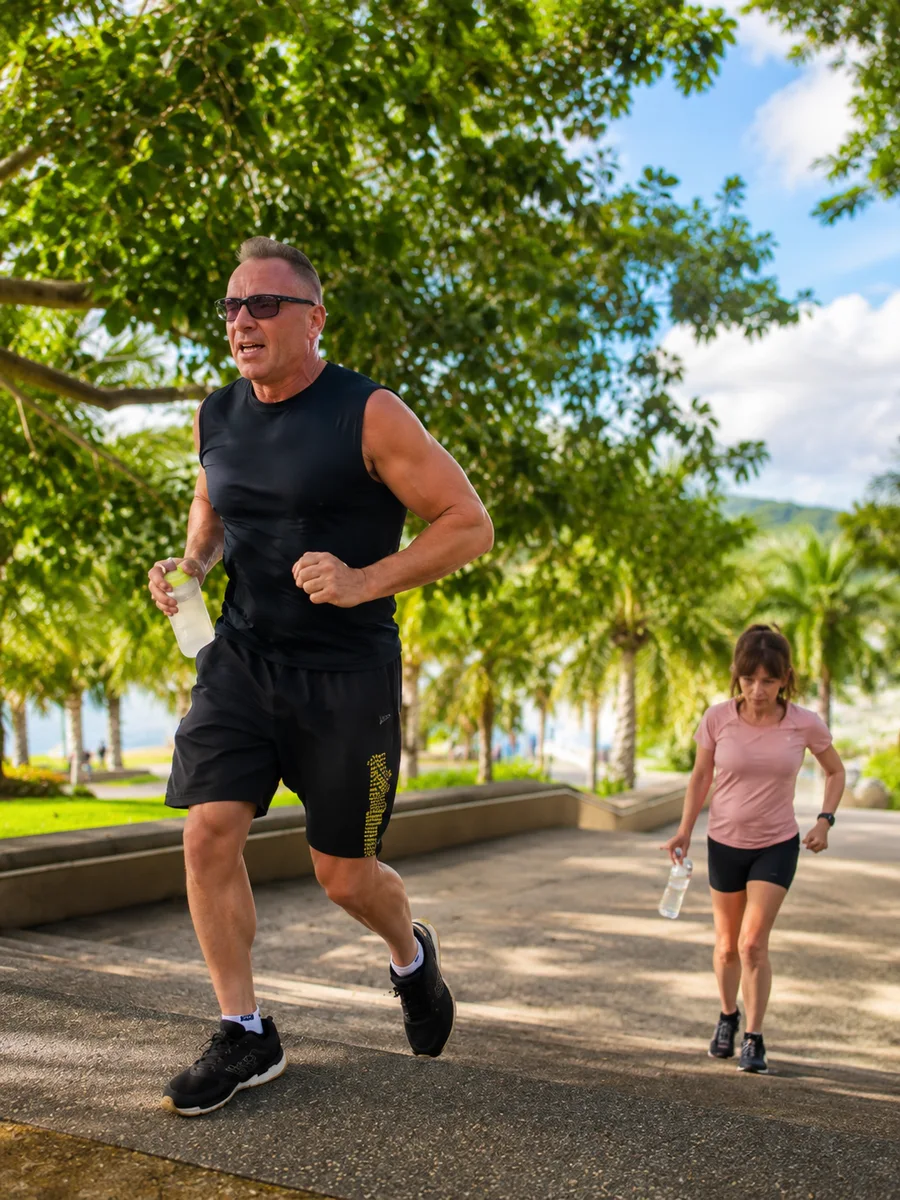 Guests running together through a palm-lined park at Phuket Cleanse