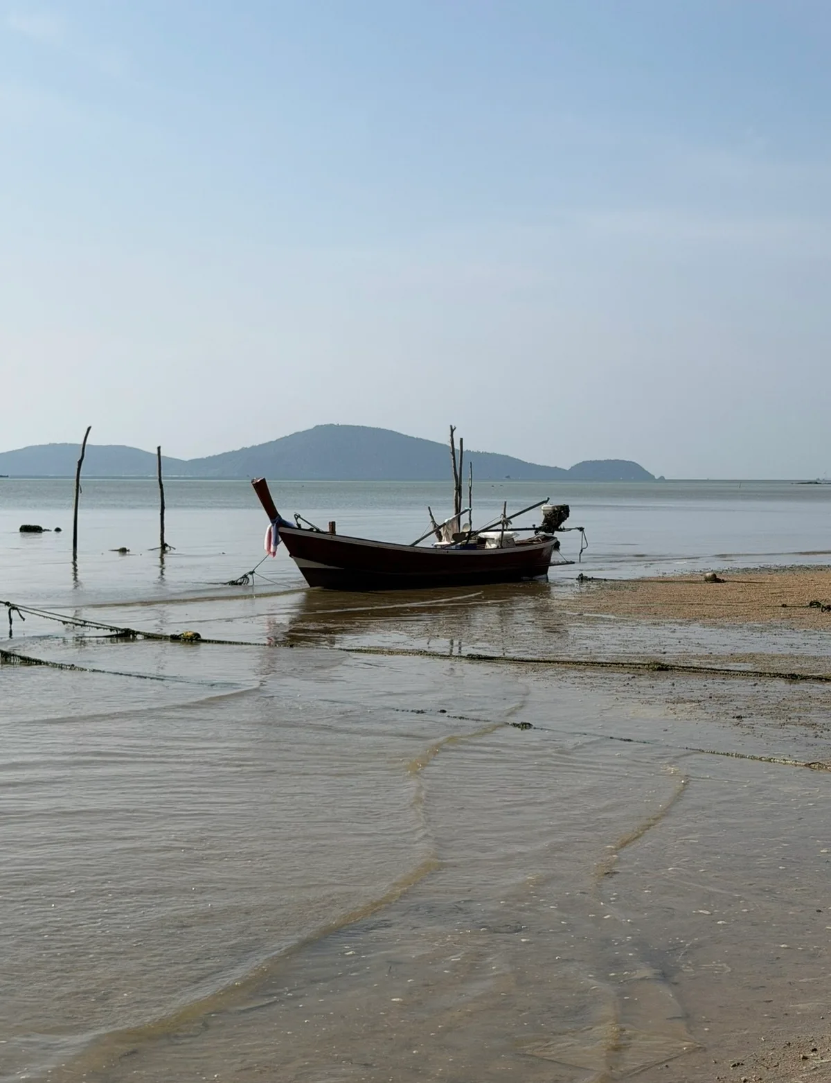 Longtail fishing boat moored at low tide on the Rawai shore